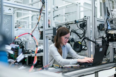 Woman using a black laptop computer in a software company